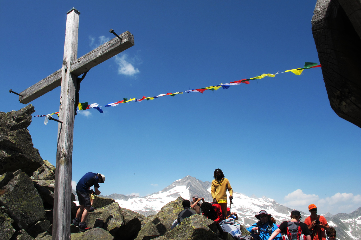 A cross and Tibetan prayer flags on the Krimmler Tauern alpine pass.